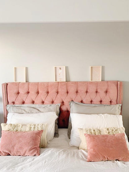 Respaldo Emmy rosa de frente, con capitoné en toda la superficie, sobre la cama de Lilian
