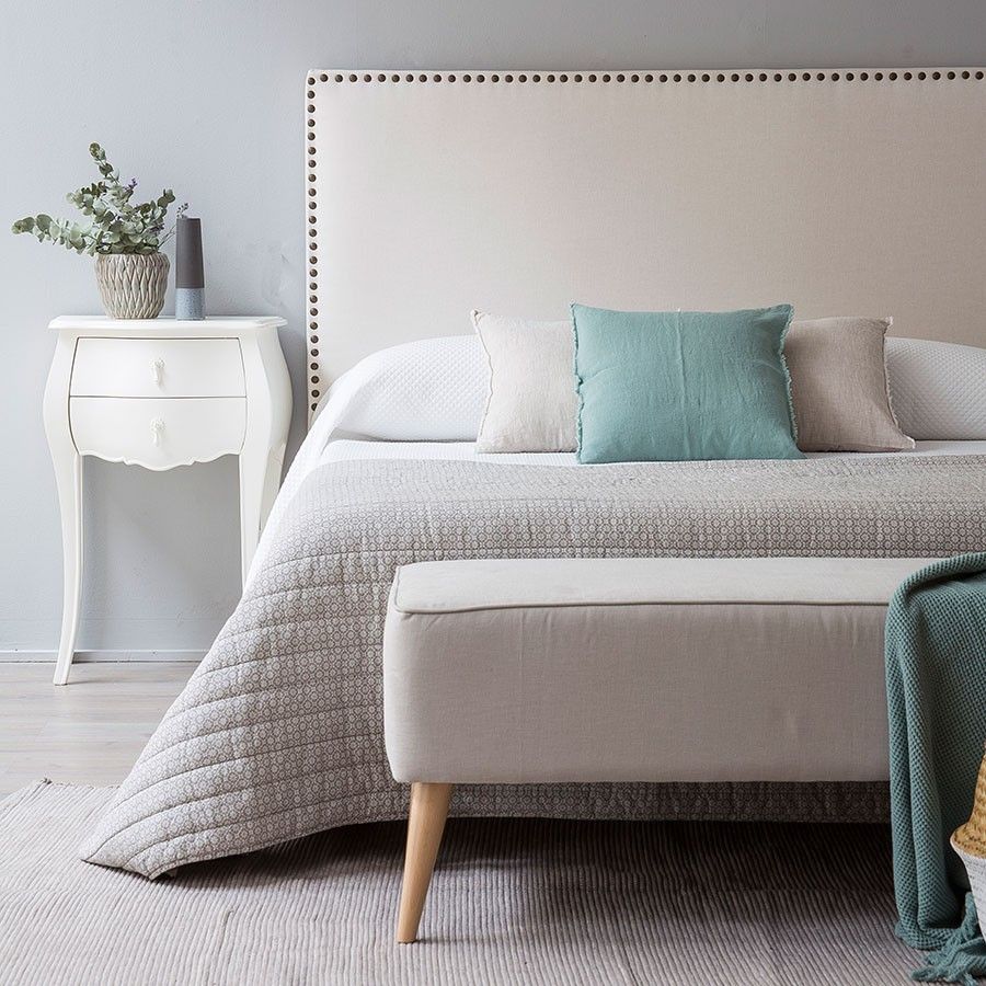 Respaldo de cama Molly tapizado en tela lisa con contorno decorado por una línea de tachas metálicas, diseño elegante y moderno para dormitorios con estilo.