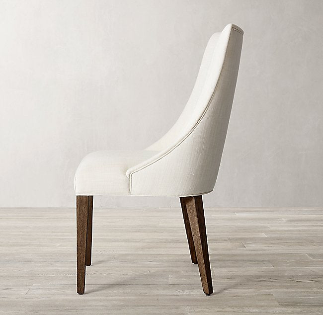 Silla Amalfi en crema de perfil, con la curva del respaldo y las patas de madera a la vista