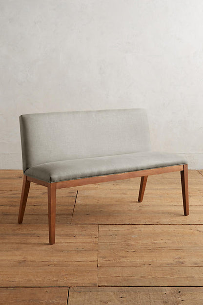 Silla Doble Nude tapizada en gris claro, con patas de madera
