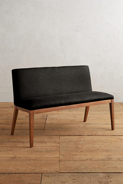 Silla Doble Nude tapizada en negro, con patas de madera