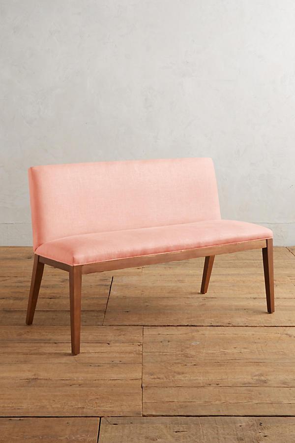 Silla Doble Nude tapizada en rosa, sobre piso de madera