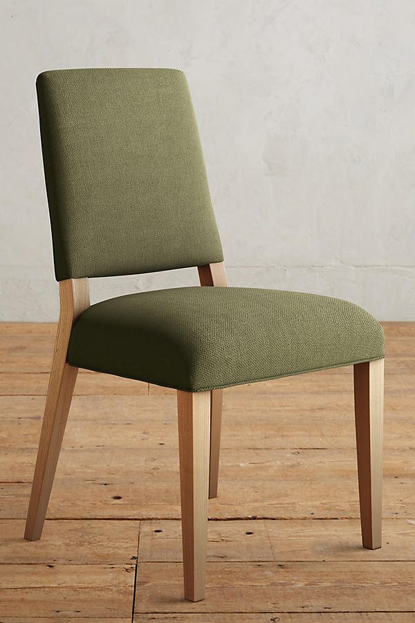 Silla Nude tapizada en verde oliva, con patas de madera