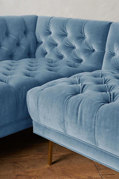 Detalle del capitoné del Sillón esquinero Bella Donna en celeste, también en el asiento, con patas de madera