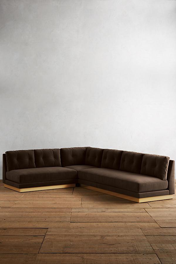 Sillón esquinero Cardiff en marrón con base de madera, vista de frente sobre piso de madera