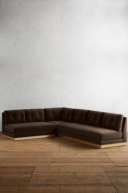 Sillón esquinero Cardiff en marrón con base de madera, vista de frente sobre piso de madera