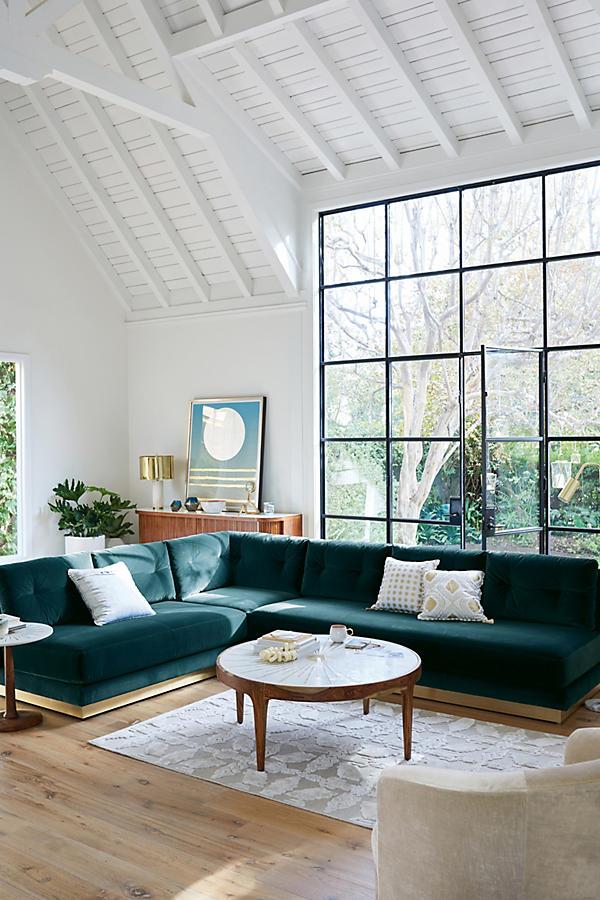 Sillón esquinero Cardiff en verde inglés en un living con techo de madera y ventanal