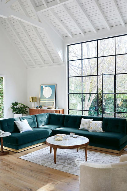 Sillón esquinero Cardiff en verde inglés en un living con techo de madera y ventanal