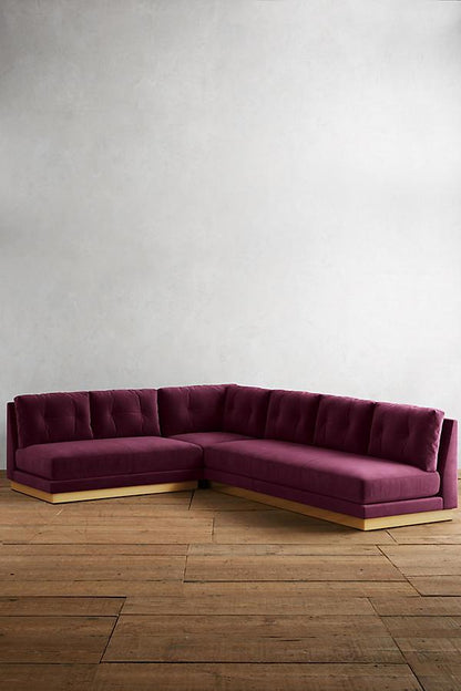 Sillón esquinero Cardiff en violeta con base de madera, sobre piso de tablas anchas