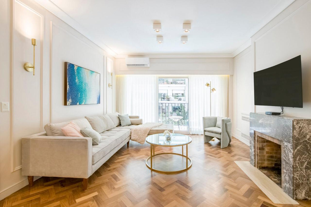 Sillón esquinero Bambú en crudo visto de frente, con almohadones celestes y rosa sobre parquet