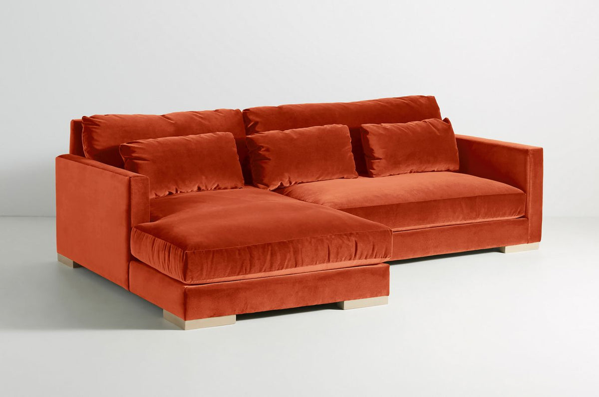 Sillón esquinero Steven en rojo con almohadones de respaldo y riñoneros, vista desde el chaise longue