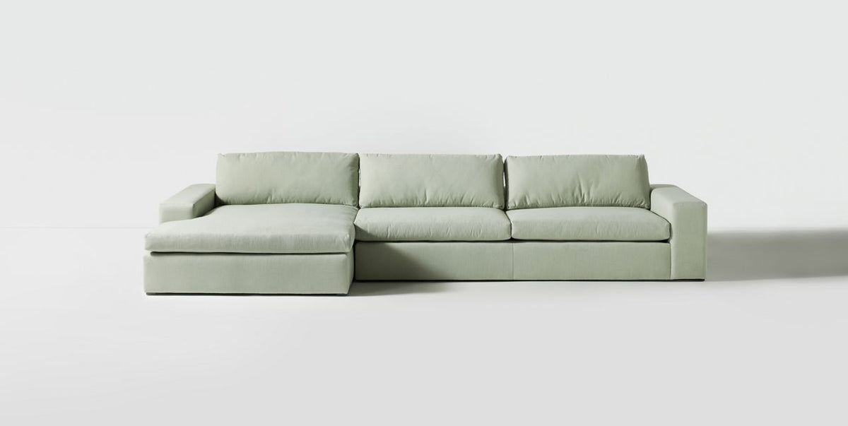 Sillón esquinero Victoria en gris verdoso, vista en diagonal de los almohadones de respaldo grandes