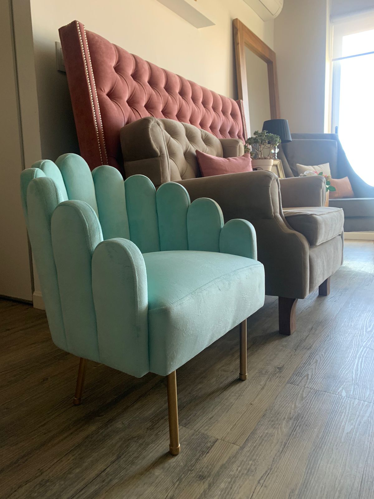 Mini Angie celeste junto a un sillón capitoné gris y un respaldo de cama rosa