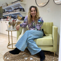 Lilian, de Tienda de Banquitos, sentada en el Sillón Mila de pana Velutti lima con patas doradas, en stock con entrega inmediata