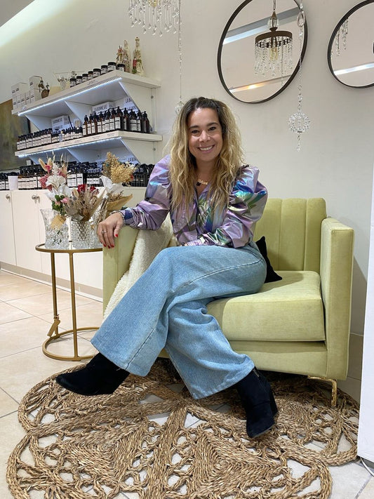 Lilian, de Tienda de Banquitos, sentada en el Sillón Mila de pana Velutti lima con patas doradas, en stock con entrega inmediata