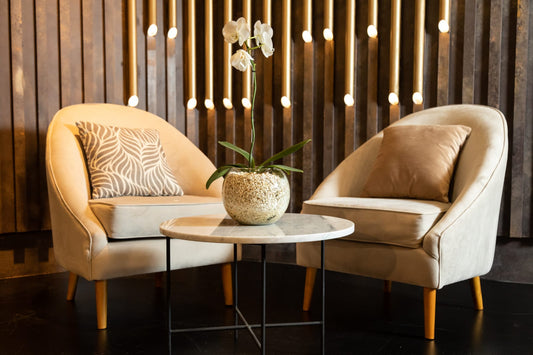 Sillón Paris de un cuerpo tapizado en beige con patas de madera, en ambiente residencial de cliente. Diseño redondo y envolvente. Tienda de Banquitos, Buenos Aires.