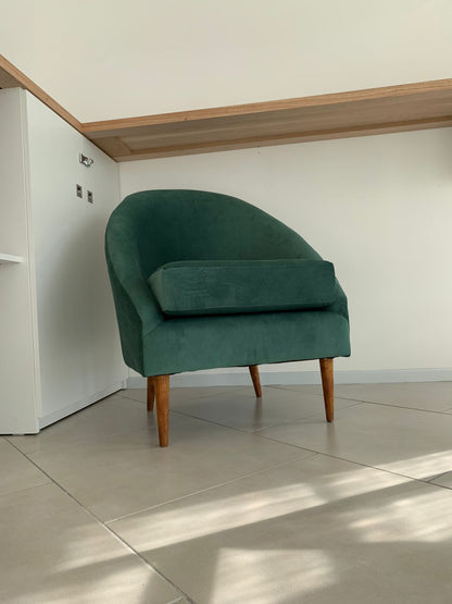 Sillón París verde con almohadón y patas de madera, en un departamento de rental en Ushuaia