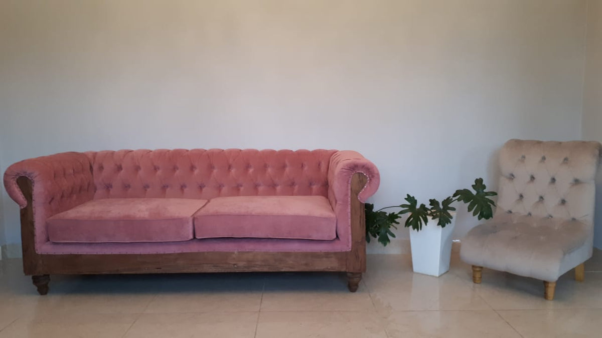 Sofá Deconstructed rosa junto a la Butaca Oriana beige con capitoné y patas torneadas, en el living de Valle