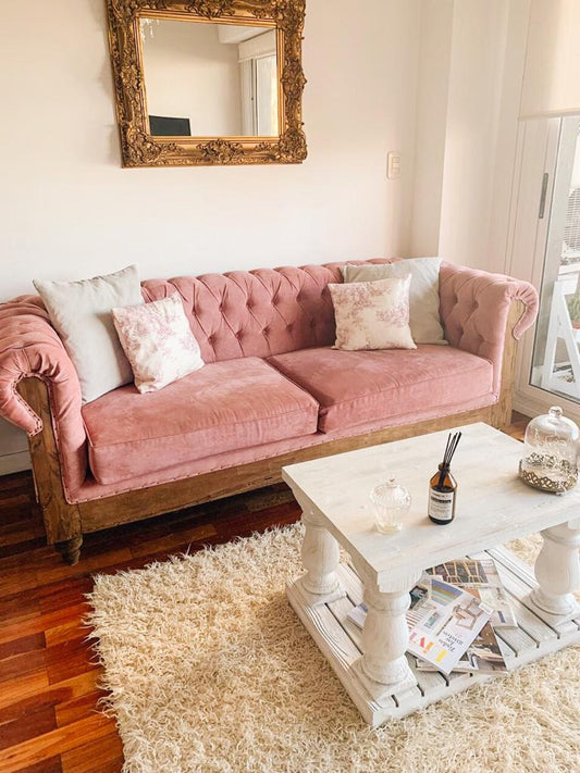Sofá Deconstructed en pana rosa con base rústica a la vista, frente a una mesa ratona blanca, en el living de Lilian en Caballito